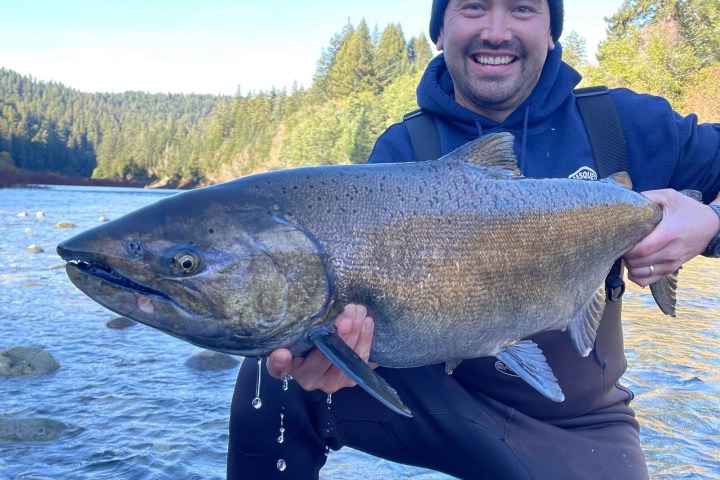 a man holding a fish in the water